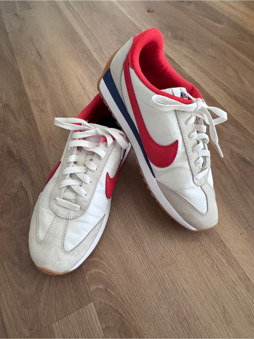 Nike Women's White Sneakers with Red Swoosh and Blue Accent